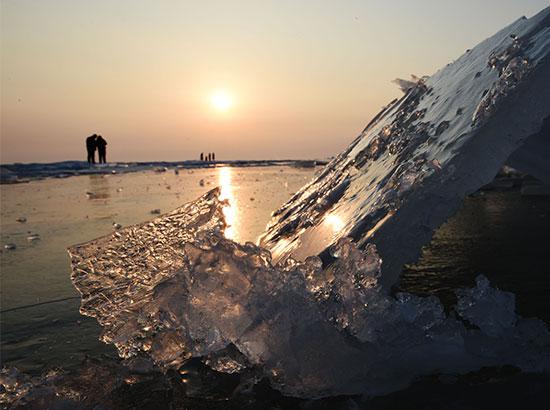 Visitors walk near ice floe on the Xingkai Lake, border lake between China and Russia