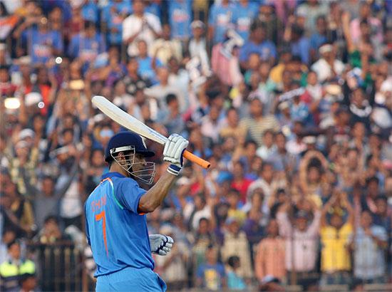 MS Dhoni of india raises his bat to celebrate his century